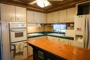 a kitchen with stainless steel appliances granite countertop a refrigerator a stove and white cabinets with wooden floor