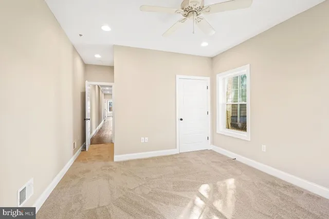 a view of a hallway with wooden floor and a window