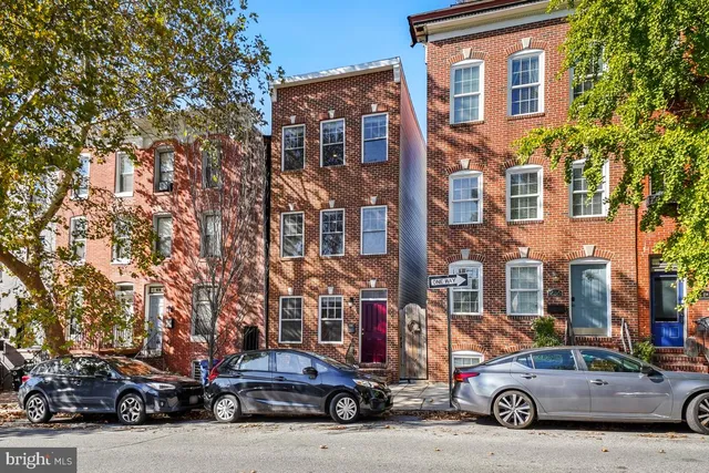 a view of an empty room with wooden floor and staircase