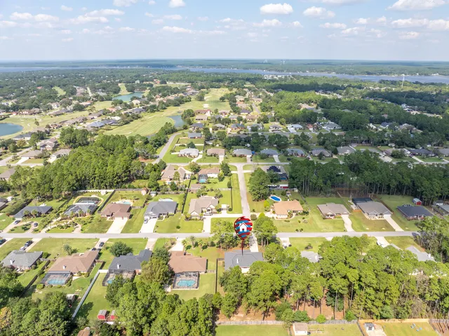 an aerial view of residential houses with outdoor space and trees