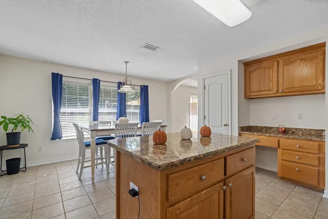 a kitchen with granite countertop cabinets a table and chairs in it
