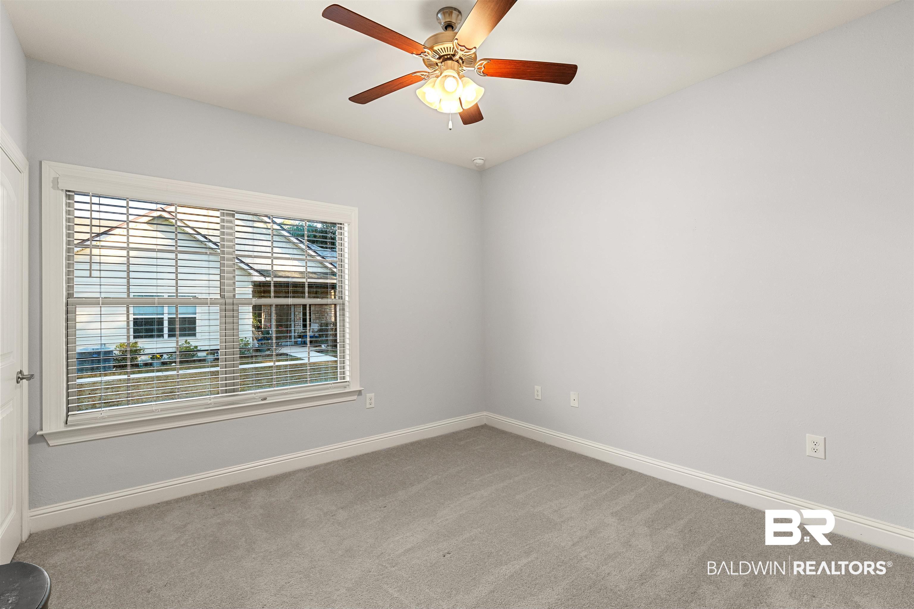702 Holmes Avenue, Unit 702 Foley, AL 36535 - Photo 15 of 33 Spare room featuring ceiling fan and carpet