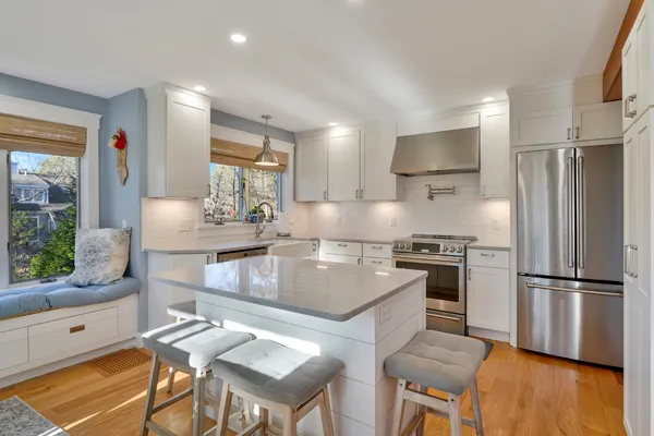 a kitchen with kitchen island a stove a sink and a refrigerator