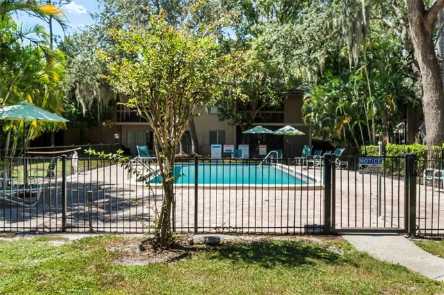 an aerial view of a house with a yard and a large tree