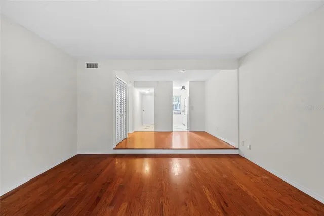 a view of empty room with wooden floor