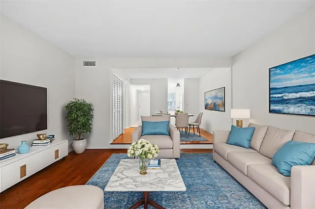 a living room with furniture flat screen tv and wooden floor