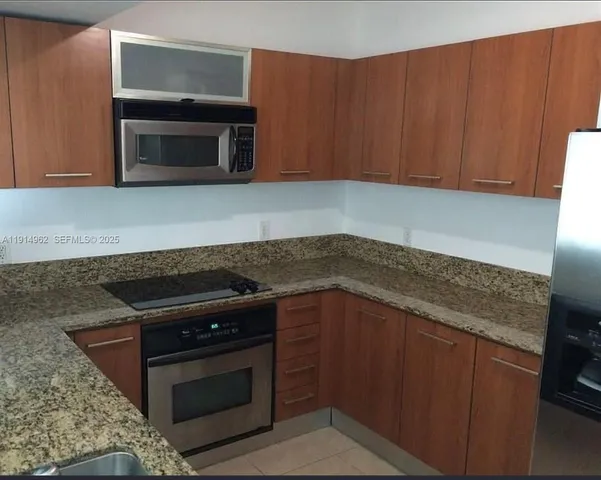 a kitchen with granite countertop a stove and a microwave