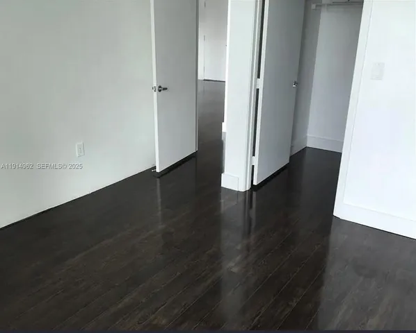 an empty room with wooden floor and closet