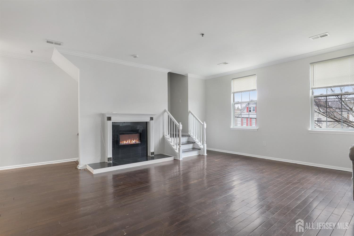 130B Remsen Avenue, Unit B New Brunswick, NJ 08901 - Photo 7 of 29 an empty room with wooden floor a fireplace and windows