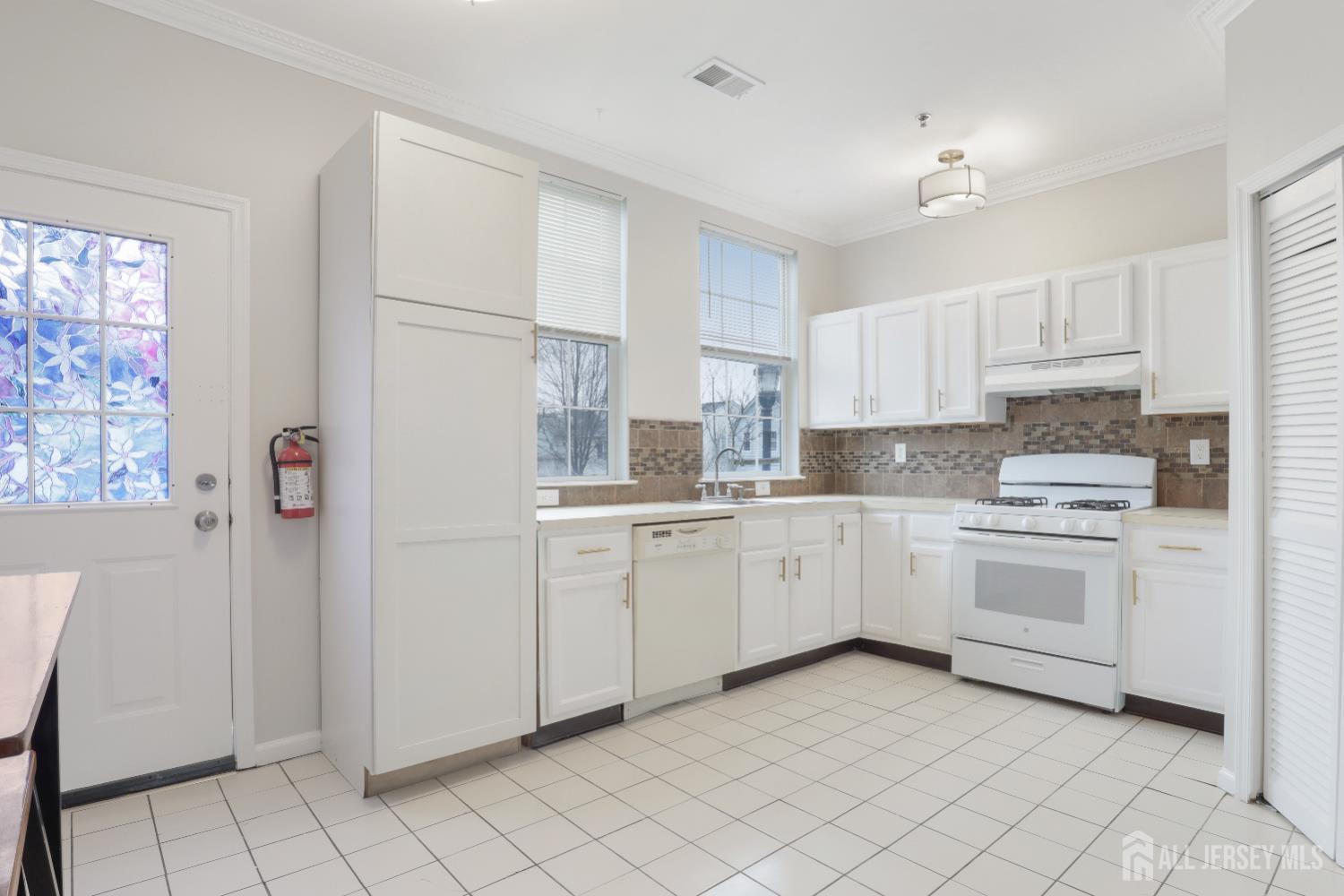 130B Remsen Avenue, Unit B New Brunswick, NJ 08901 - Photo 9 of 29 a kitchen with white cabinets and white appliances