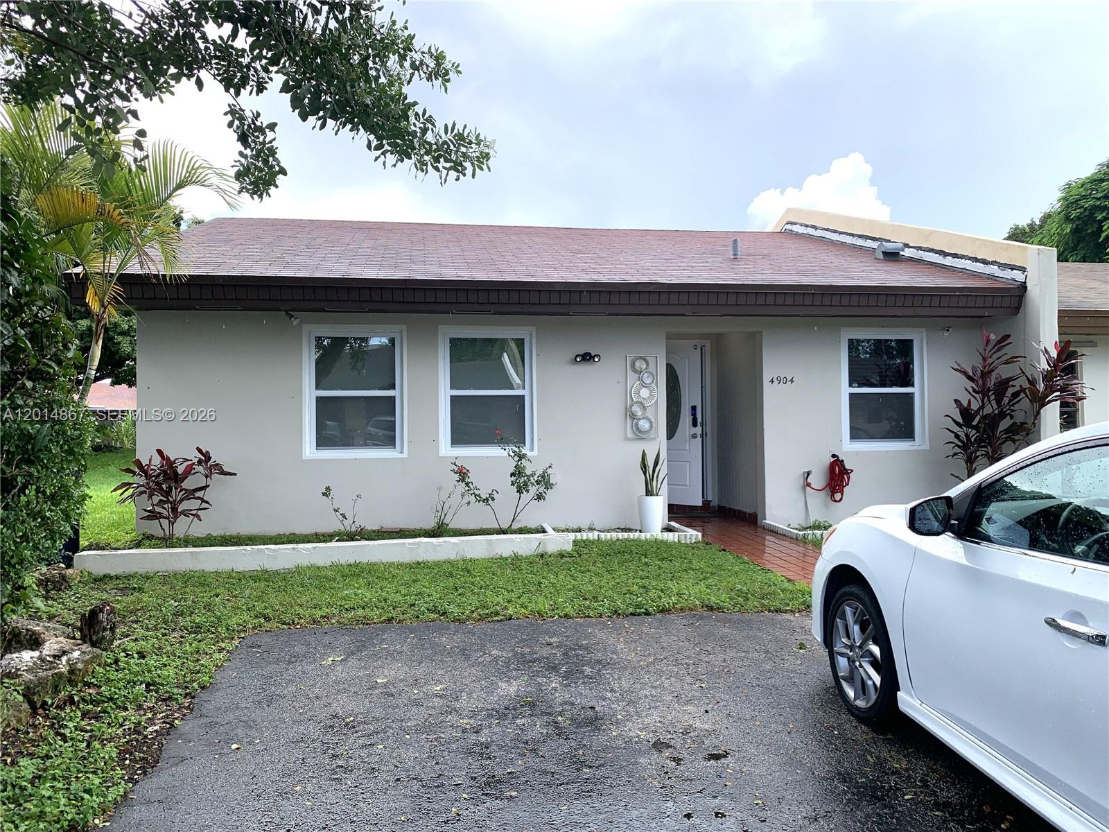 4904 Southwest 139th Court Miami, FL 33175 - Photo 1 of 20 a front view of a house with a yard and garage