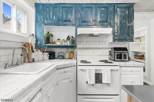 a kitchen with granite countertop a sink stainless steel appliances and cabinets