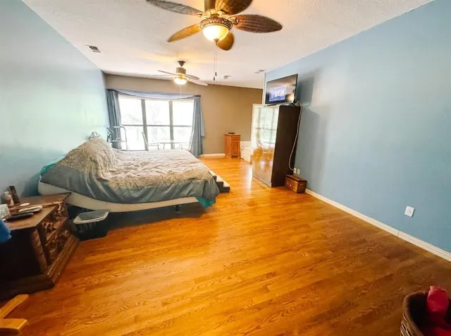 a spacious bedroom with a bed and a mirror