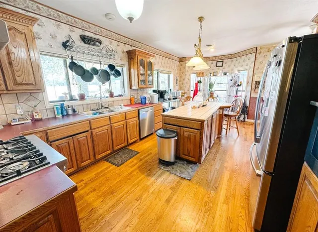 a view of a kitchen with refrigerator and window