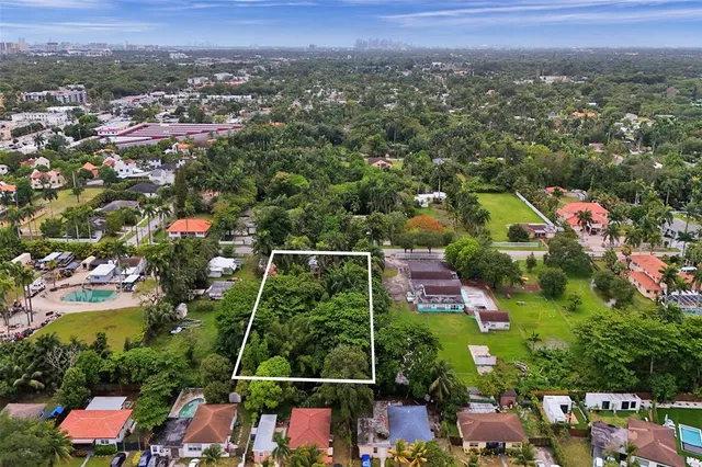 an aerial view of residential houses with outdoor space and swimming pool