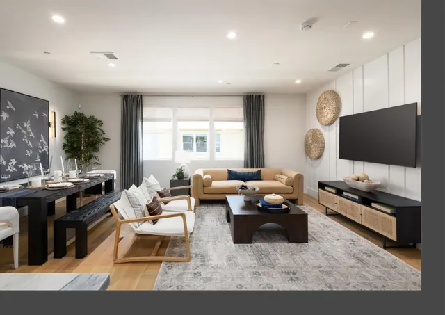 a living room with furniture a flat screen tv and a large window