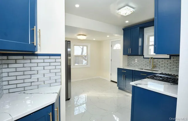 a kitchen with a sink a stove cabinets and a wooden floor