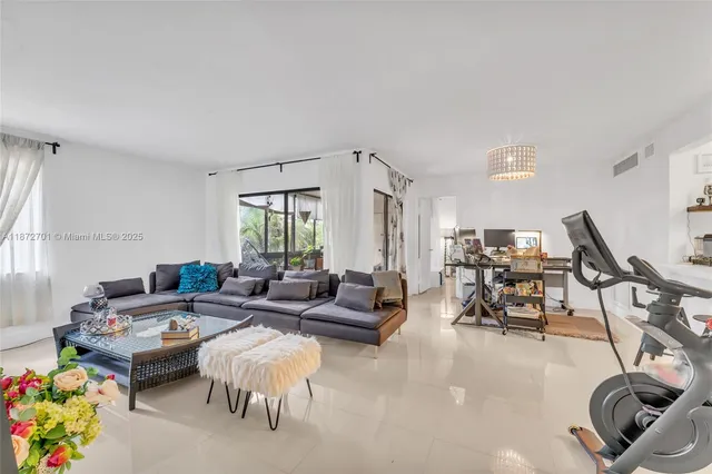 a living room with furniture a flat screen tv and a floor to ceiling window