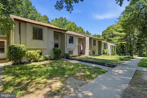 a view of a house with backyard and trees