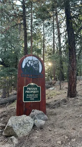 a sign that is sitting in front of a tree