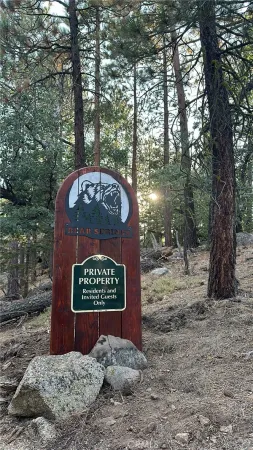 a sign that is sitting in front of a tree