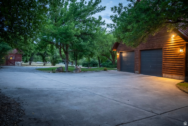 435 Canyon Road Millville, UT 84326 - Photo 81 of 113 Two-car garage featuring horizontal wood siding and panel garage doors