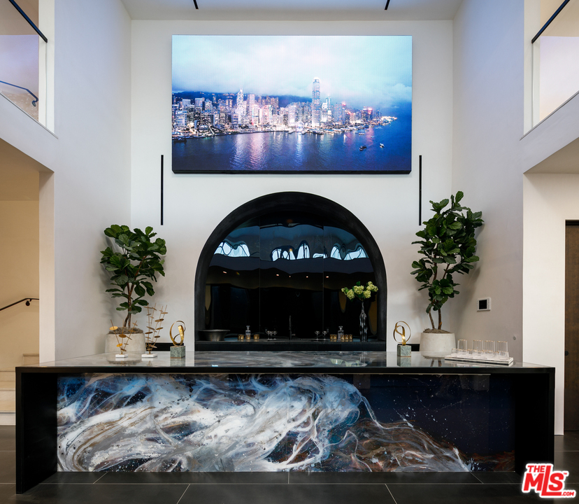 10697 Somma Way Los Angeles, CA 90077 - Photo 17 of 25 a fireplace with a vase of flowers on top of it