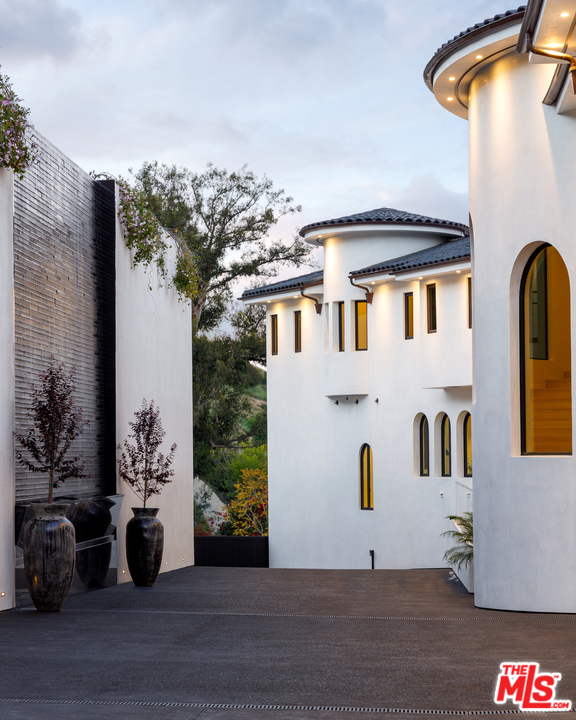 10697 Somma Way Los Angeles, CA 90077 - Photo 3 of 25 a front view of a house with a potted plant