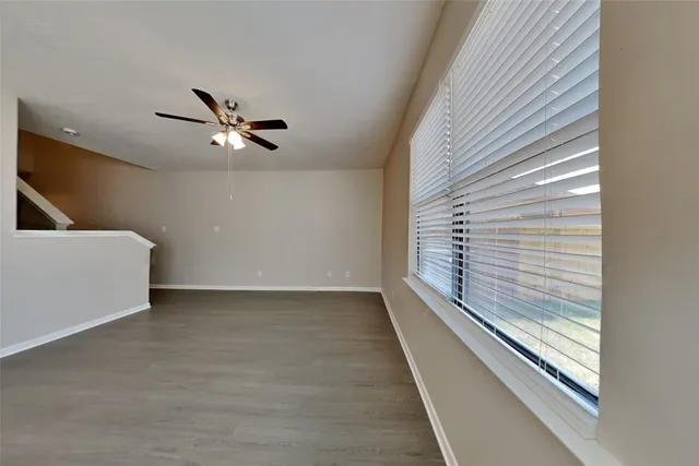 a view of a livingroom with a ceiling fan and window