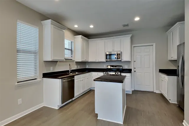 a kitchen with stainless steel appliances granite countertop a stove a sink and a refrigerator