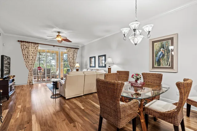 a view of a dining room with furniture a chandelier and wooden floor