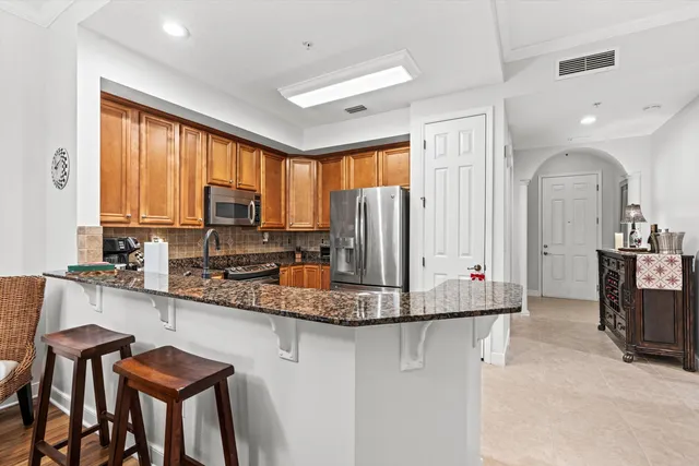 a kitchen with stainless steel appliances granite countertop sink a refrigerator and cabinets