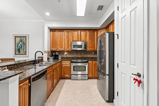 a kitchen with stainless steel appliances granite countertop a stove sink and cabinets