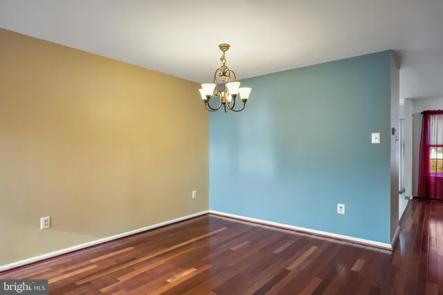 a view of a room with wooden floor and chandelier