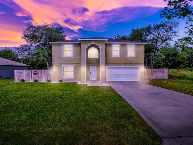 a front view of a house with garden and patio