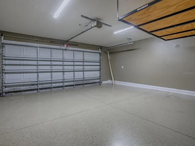 an empty room with wooden floor ceiling fan and windows