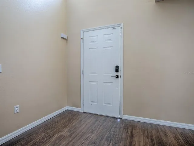 a view of an empty room with wooden floor