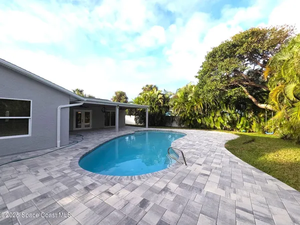 a view of a house with pool fire pit next to a yard