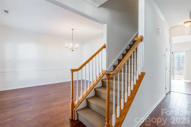 a view of staircase with wooden floor and fan