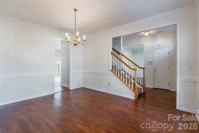a view of a hallway with wooden floor and stairs
