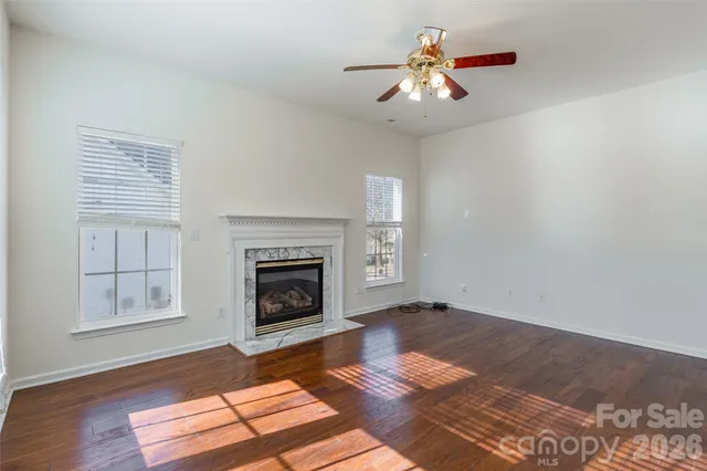 an empty room with windows and fireplace