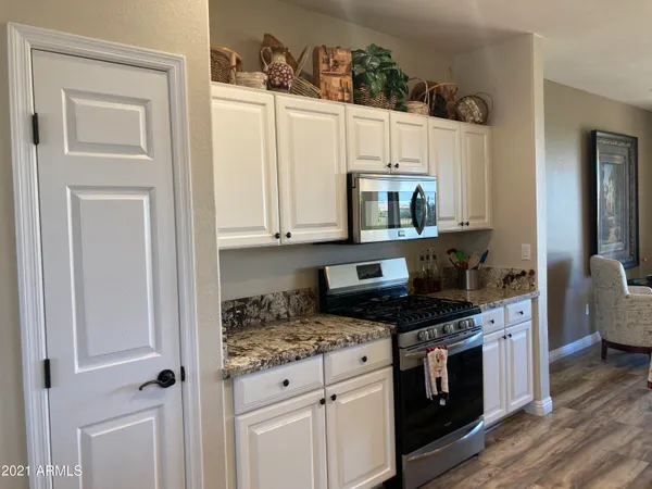 a kitchen with white cabinets and appliances