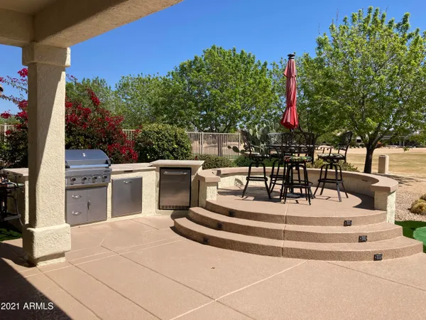 a view of a patio with dining table and chairs with wooden floor and fence