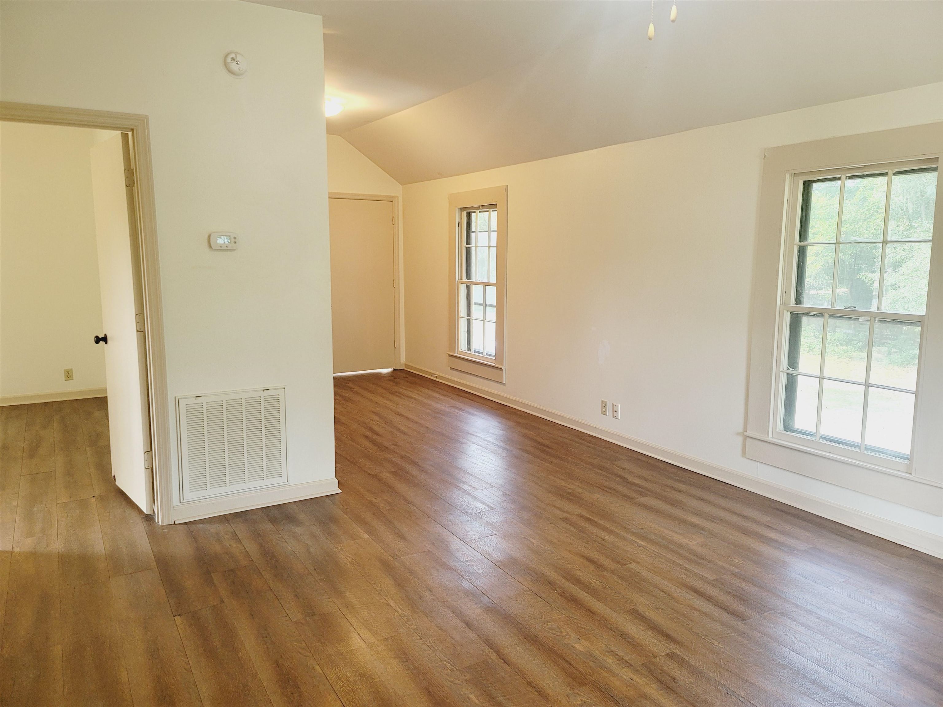 302 Jefferson Street, Unit 2 Springfield, GA 31329 - Photo 15 of 23 an empty room with wooden floor and windows