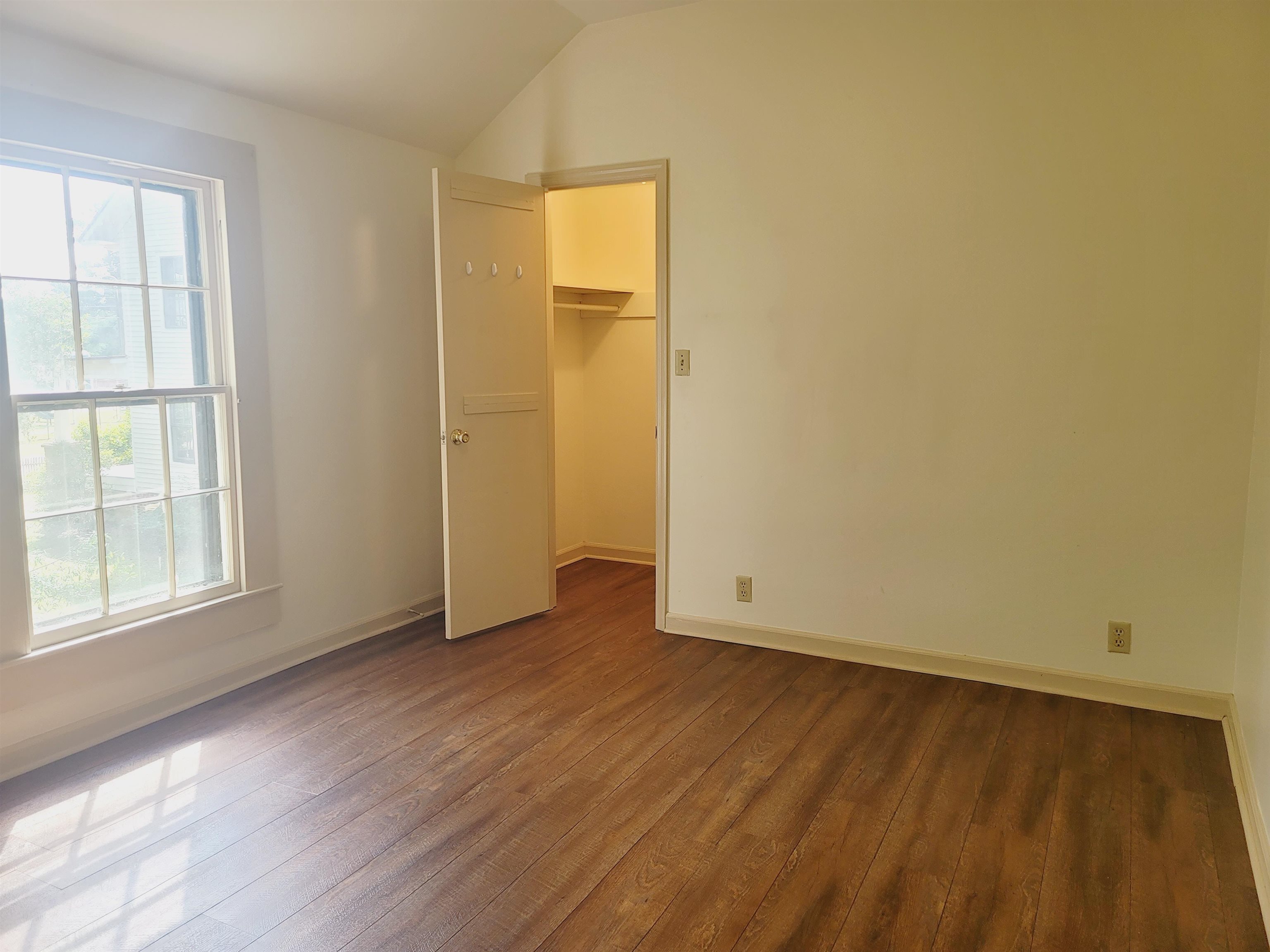 302 Jefferson Street, Unit 2 Springfield, GA 31329 - Photo 16 of 23 an empty room with wooden floor and windows