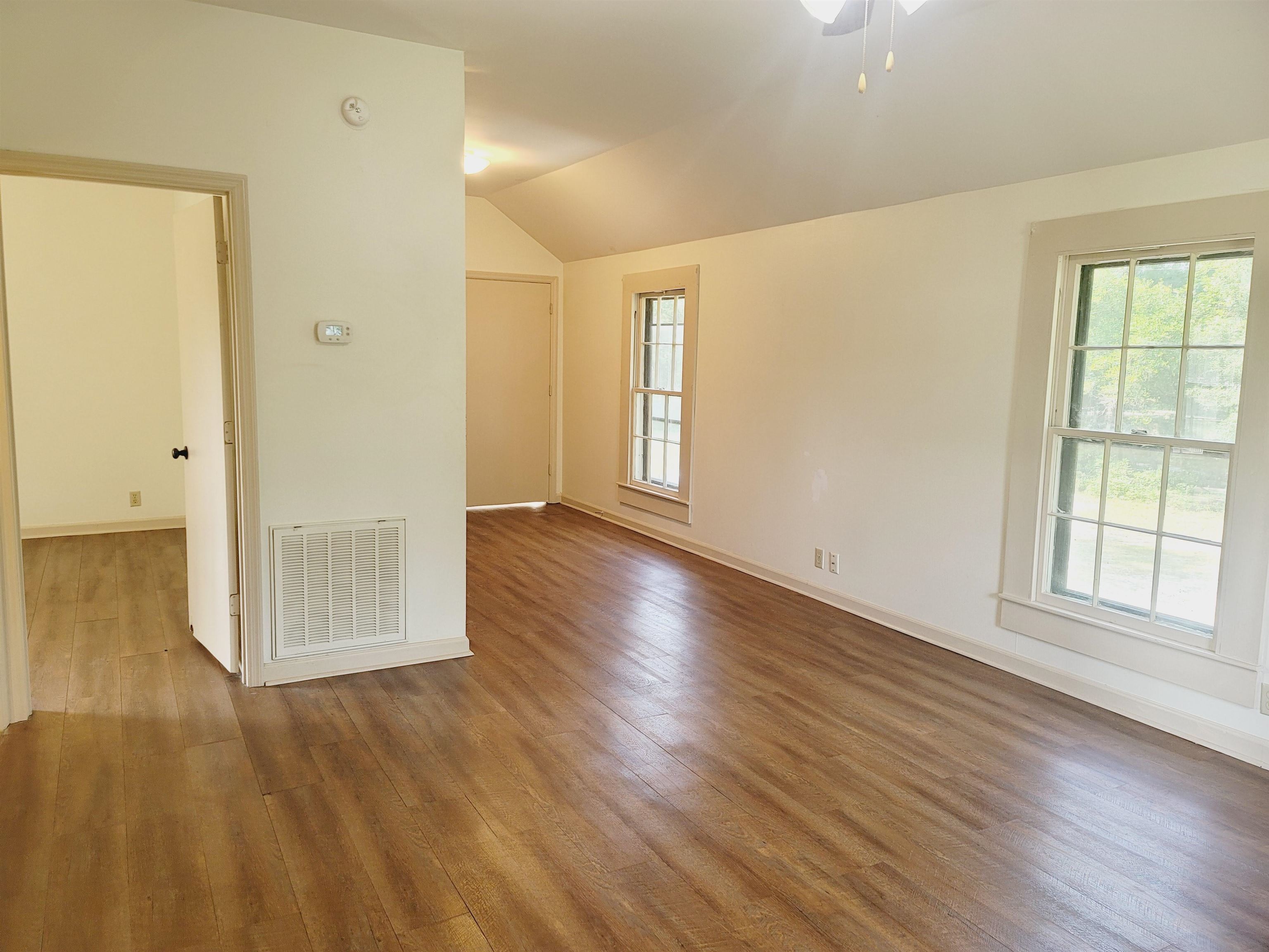 302 Jefferson Street, Unit 2 Springfield, GA 31329 - Photo 17 of 23 an empty room with wooden floor and windows