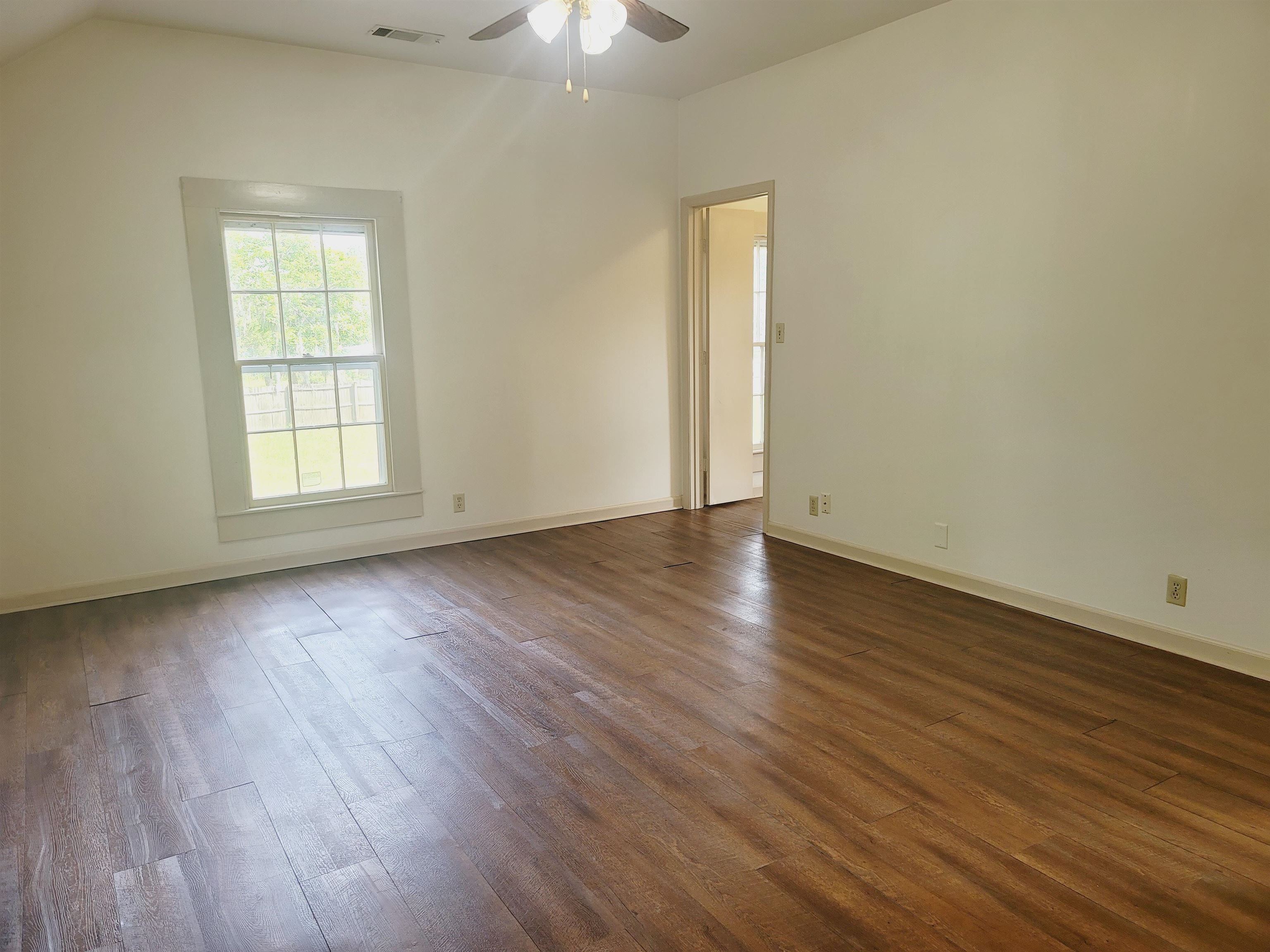 302 Jefferson Street, Unit 2 Springfield, GA 31329 - Photo 23 of 23 an empty room with wooden floor and windows