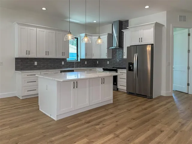 a kitchen with a sink a stove a refrigerator and cabinets