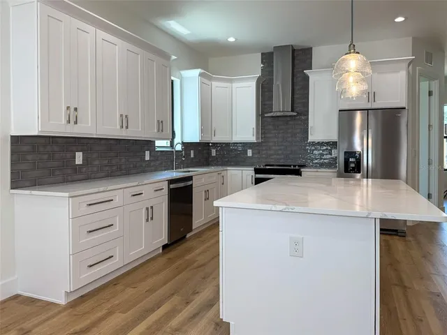 a kitchen with granite countertop white cabinets and black appliances