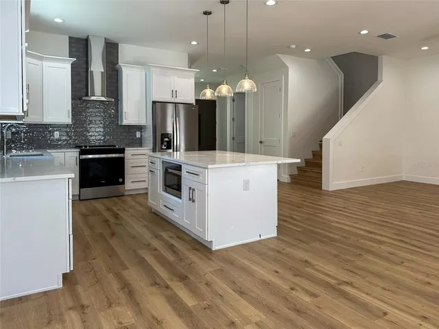 a view of a hallway with wooden floor and entryway